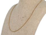 un collier en or sur un mannequin, sur fond blanc