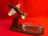 un cendrier en verre sur lequel repose un couteau, sur fond rouge