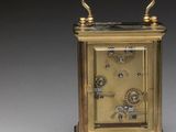 an image of a small brass clock sitting on top of a table