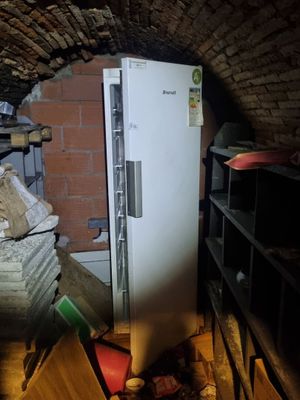 une photo d'un réfrigérateur dans une pièce aux murs en briques