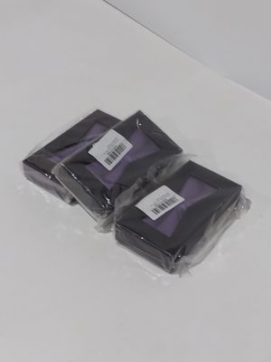 trois sacs contenant des objets noirs et violets posés sur une surface blanche