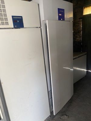 deux réfrigérateurs blancs dans une pièce aux murs en briques