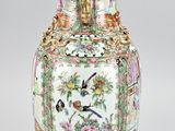 a vase that has a bird and flowers on it