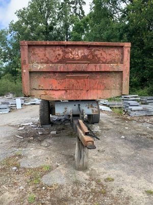 a red dump truck that is parked in the dirt