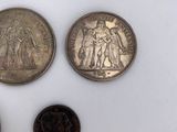 three different types of coins sitting on top of a white surface