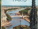 the book is on a table with a view of a river and a bridge
