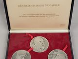 three commemorative medals in a red box with a red ribbon
