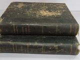 two old books stacked on top of each other on a table