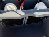 the back of a red car with its trunk open and seats folded down