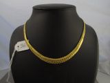 un gros plan d'un collier en or sur un mannequin