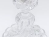 clear glass candle holder on a white surface with a black candle