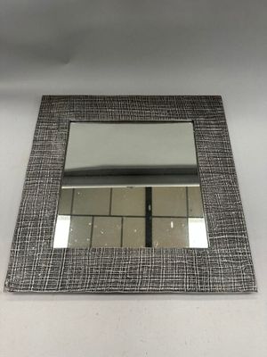 miroir rectangulaire dont le cadre est orné d'un motif noir et blanc