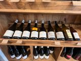 Des bouteilles de vin sont alignées sur une étagère en bois dans un caviste