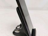 a cell phone that is on a stand on the table