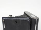 an old black camera sitting on top of a white surface