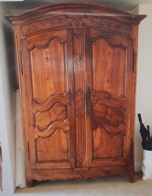 une grande armoire en bois dans le coin d'une pièce