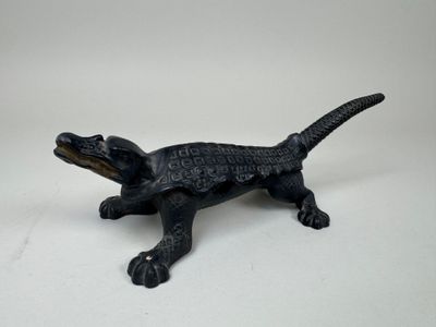 black alligator figurine on a white background