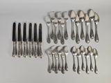 un grand nombre de cuillères et de fourchettes en argent disposées sur une table