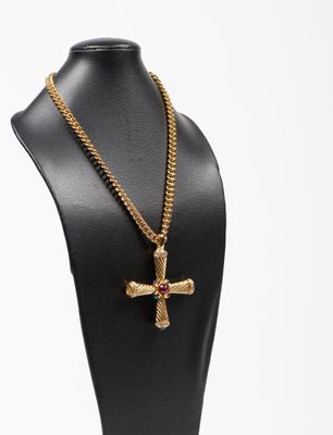 une chaîne en or avec un pendentif en forme de croix sur un mannequin