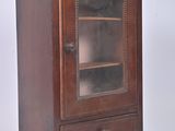 a small wooden cabinet with a glass door on it