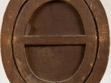 a round window with a wooden frame on the wall