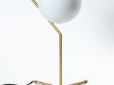 une image représentant une lampe posée sur un pied, sur une surface blanche