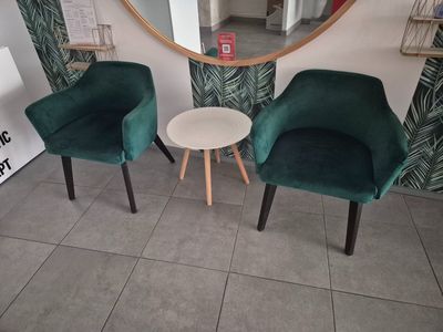 deux chaises et une table dans une pièce où se trouve un miroir