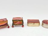 trois boîtes miniatures sont alignées sur une surface blanche