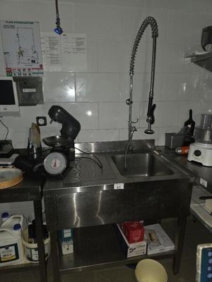 une cuisine équipée d'un évier en inox et d'un plan de travail