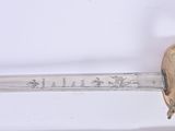 a silver sword with a gold handle on a white surface