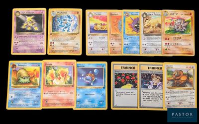 Plusieurs cartes Pokémon sont alignées sur une surface noire
