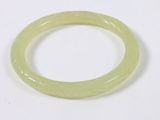 a close up of a green bracelet on a white surface