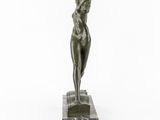 a bronze statue of a woman standing on a marble base