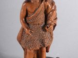 l'image d'une statue d'un homme assis sur un rocher