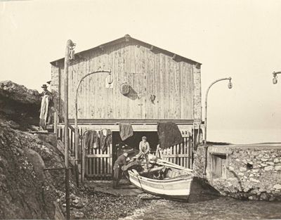 an old black and white photo of a boat in front of a house