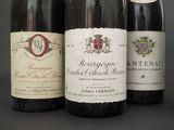 three bottles of wine are lined up on a table