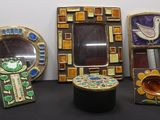 Plusieurs œuvres d'art sont exposées sur une table sur laquelle se trouve un miroir