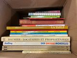 plusieurs livres empilés dans une boîte
