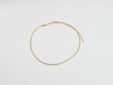 un bracelet en chaîne d'or à chaîne unique sur fond blanc
