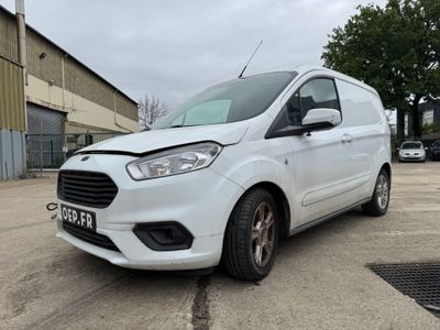 une camionnette blanche garée sur un parking à côté d'un bâtiment