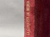 un livre rouge posé sur une table blanche
