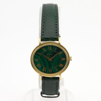 une image représentant une montre verte dont le cadran est orné de chiffres romains