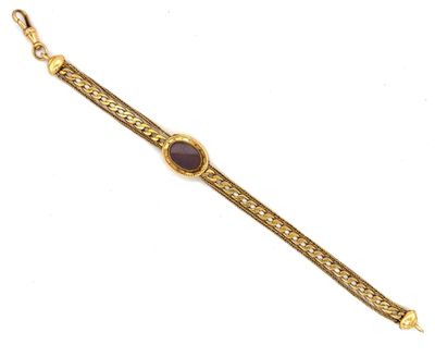 a gold bracelet with a purple stone on a chain