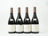 quatre bouteilles de vin sont alignées sur une surface blanche