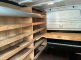 shelves in the back of a white van filled with lots of wood