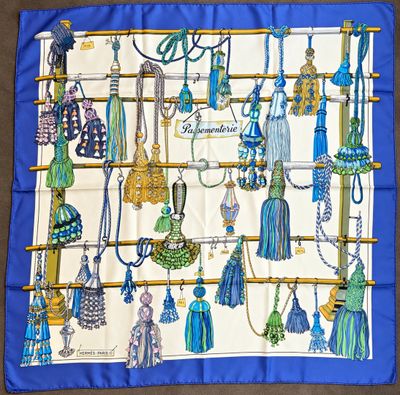 a blue and white scarf with a bunch of tassels on it