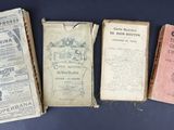 several old books are lined up on a blue surface