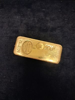 un gros plan d'un lingot d'or posé sur une surface noire