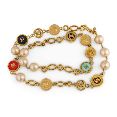 a close up of a bracelet with pearls and charms