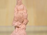 une petite statue représentant une personne tenant un poisson